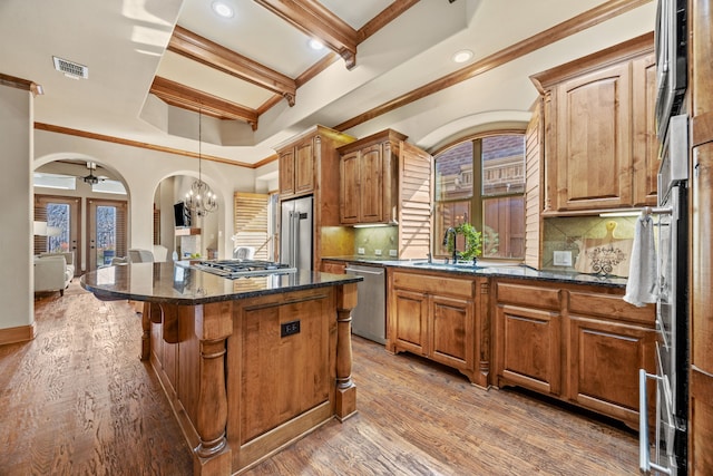 kitchen with visible vents, a center island, french doors, arched walkways, and stainless steel appliances