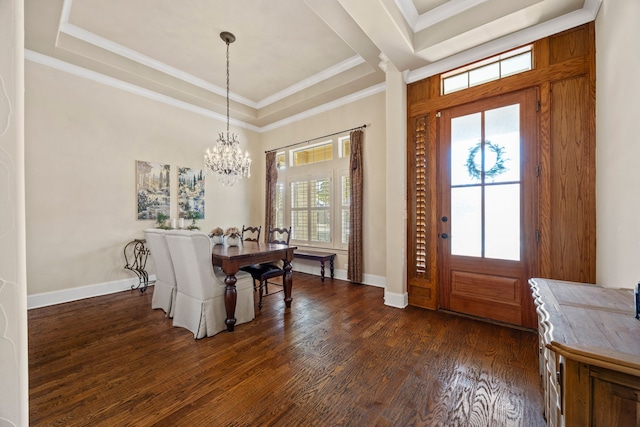 foyer with baseboards, a tray ceiling, ornamental molding, dark wood-style floors, and a notable chandelier