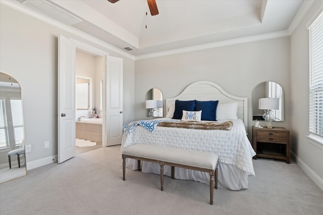 bedroom featuring connected bathroom, carpet flooring, visible vents, baseboards, and a tray ceiling