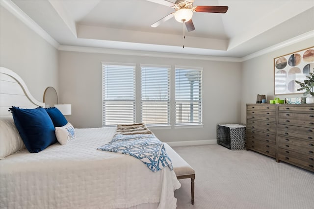 bedroom with baseboards, a raised ceiling, a ceiling fan, crown molding, and carpet floors