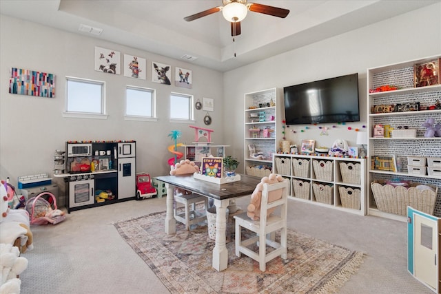 rec room featuring carpet floors, visible vents, and a tray ceiling