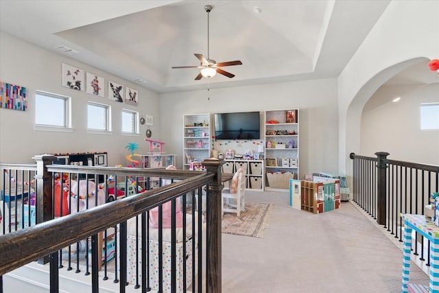 recreation room with a tray ceiling, visible vents, ceiling fan, and carpet