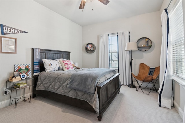 carpeted bedroom featuring multiple windows, baseboards, and a ceiling fan