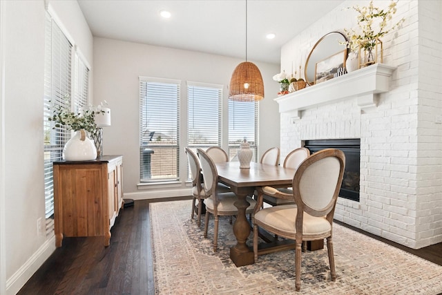 dining area with dark wood-style floors, recessed lighting, a fireplace, and baseboards