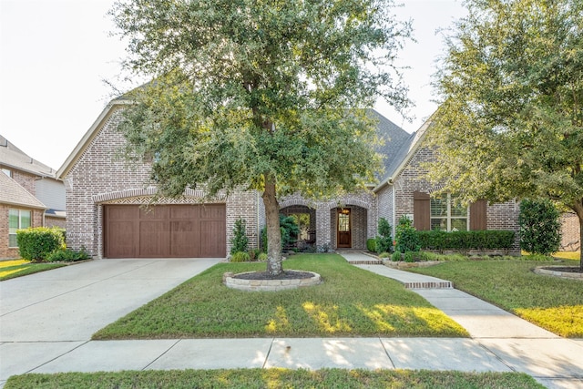 view of front facade with a garage, driveway, brick siding, and a front yard