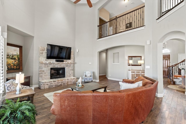 living room with baseboards, arched walkways, and dark wood-style floors