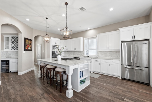 kitchen with visible vents, a center island, wine cooler, appliances with stainless steel finishes, and white cabinetry