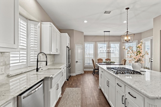 kitchen featuring visible vents, dark wood-type flooring, a chandelier, stainless steel appliances, and a sink