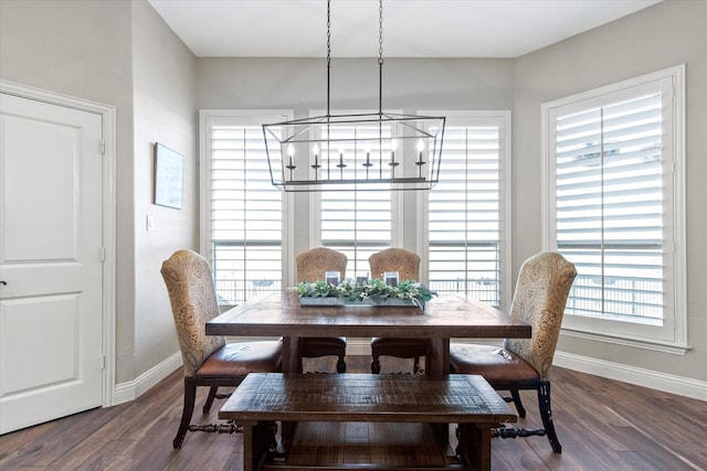 dining space with a notable chandelier, baseboards, and wood finished floors