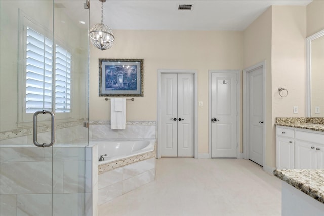 bathroom featuring vanity, visible vents, a stall shower, a garden tub, and a notable chandelier