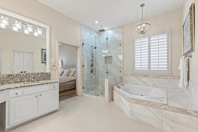 ensuite bathroom with a stall shower, ensuite bathroom, a bath, a notable chandelier, and vanity