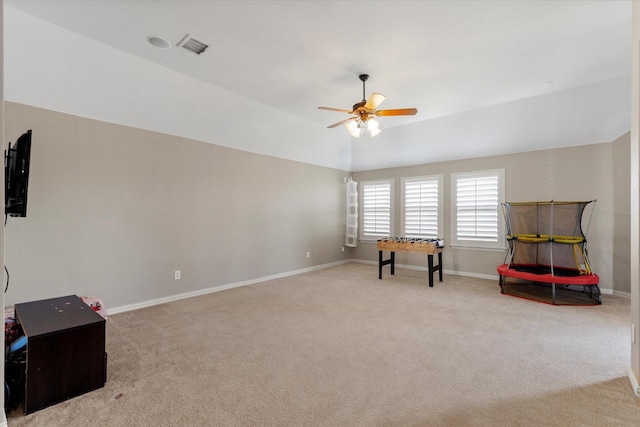 interior space with visible vents, light colored carpet, baseboards, and a ceiling fan