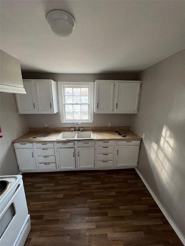 kitchen featuring dark wood-style flooring, white range with electric cooktop, light countertops, white cabinets, and a sink