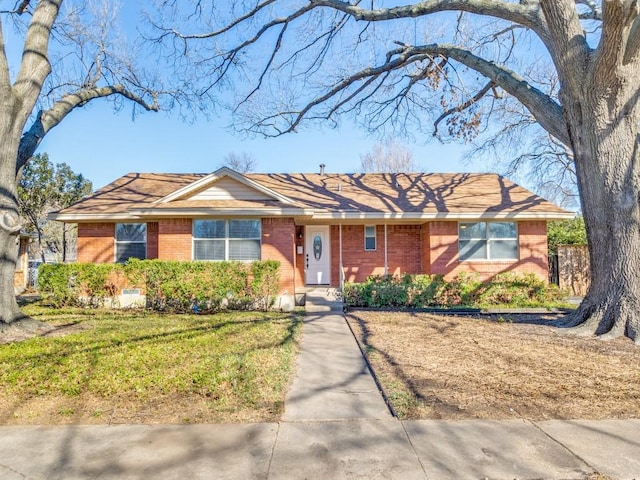 ranch-style house featuring a front yard and brick siding