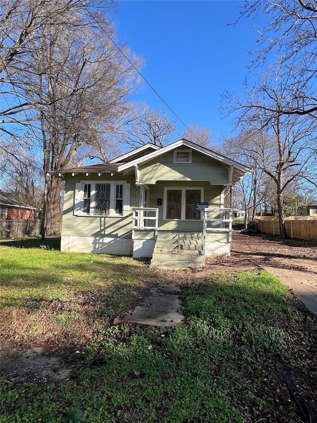 view of front of home featuring a porch and fence