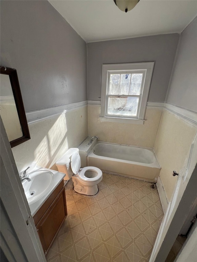 bathroom with toilet, tile patterned floors, a bath, and vanity