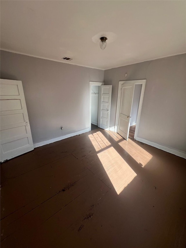 unfurnished bedroom with baseboards, a closet, and visible vents