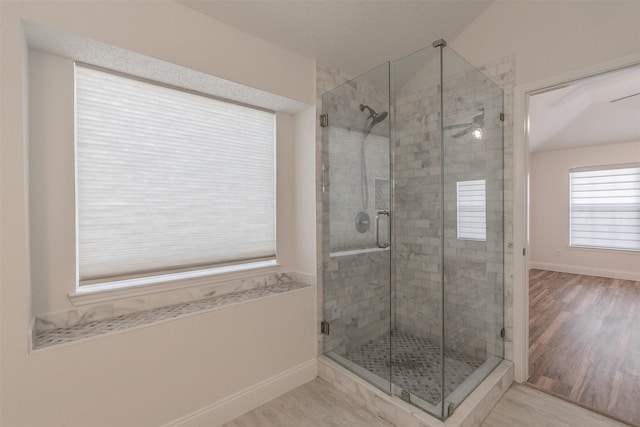 full bathroom with a shower stall, baseboards, and wood finished floors