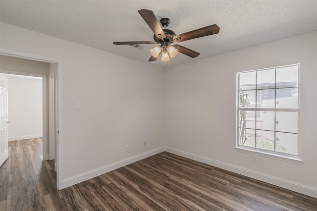 unfurnished room featuring a wealth of natural light, dark wood-style flooring, visible vents, and baseboards