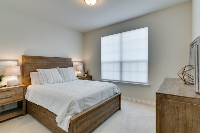 bedroom featuring light carpet and baseboards