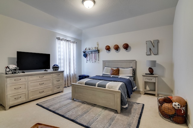 bedroom with baseboards and light colored carpet