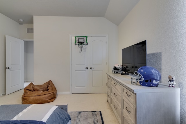 bedroom featuring lofted ceiling, visible vents, a closet, and light colored carpet