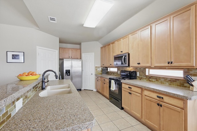 kitchen featuring light brown cabinets, stainless steel appliances, a sink, visible vents, and backsplash