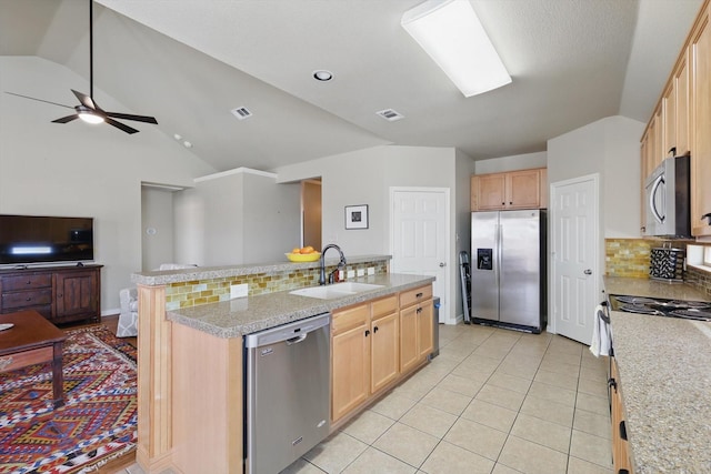 kitchen with light tile patterned floors, lofted ceiling, open floor plan, stainless steel appliances, and a sink