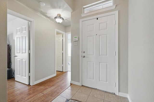 entryway with light tile patterned floors and baseboards