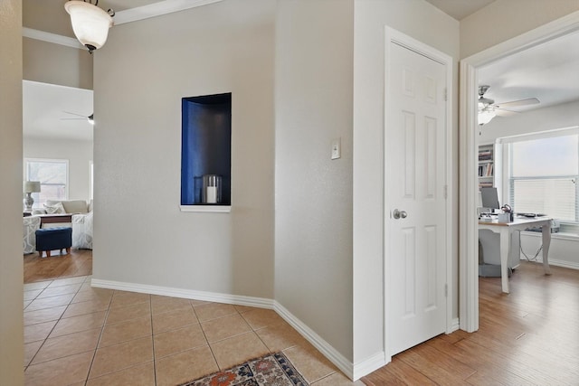 hallway featuring light tile patterned floors and baseboards