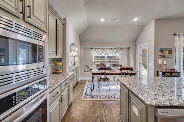 kitchen with lofted ceiling, visible vents, appliances with stainless steel finishes, and gray cabinetry