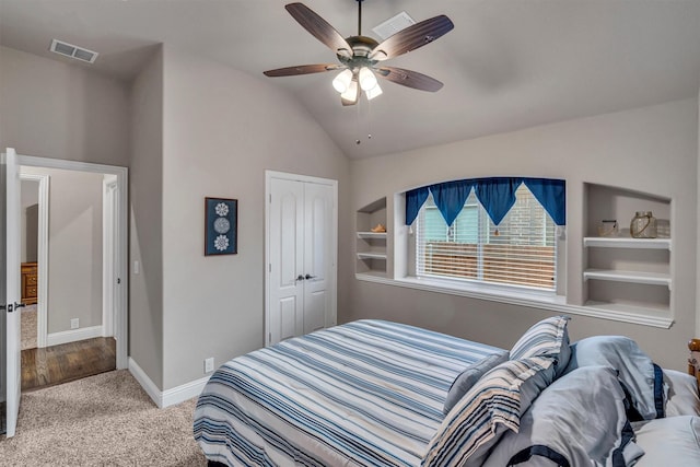 bedroom with carpet flooring, visible vents, baseboards, vaulted ceiling, and a closet