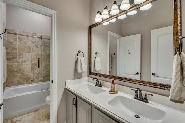 bathroom featuring double vanity, toilet, a sink, and tile patterned floors