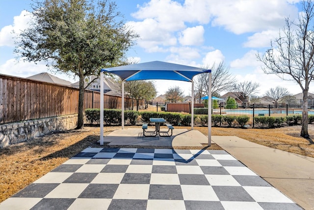 view of community with fence and a patio