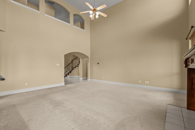 3054 Oakwood Dr, Celina, TX 75009 - unfurnished living room with a towering ceiling, arched walkways, light carpet, and ceiling fan