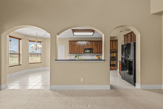 3054 Oakwood Dr, Celina, TX 75009 - kitchen featuring a chandelier, light carpet, dark countertops, black appliances, and decorative backsplash