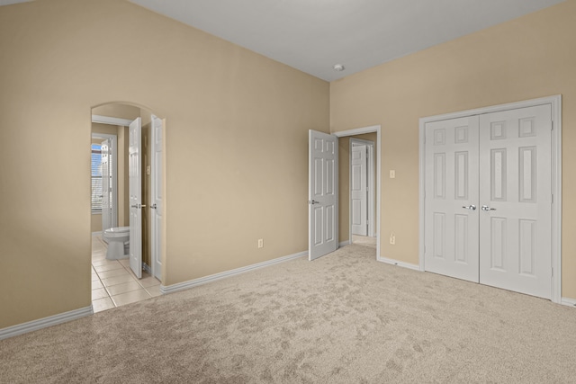 3054 Oakwood Dr, Celina, TX 75009 - unfurnished bedroom with baseboards, a closet, arched walkways, and carpet