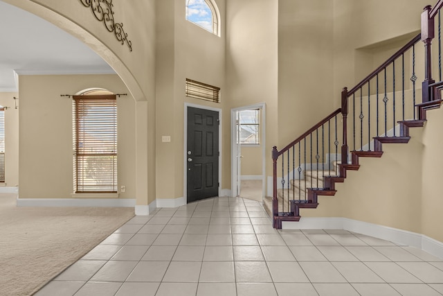 3054 Oakwood Dr, Celina, TX 75009 - carpeted entrance foyer with stairs, ornamental molding, baseboards, tile patterned floors, and arched walkways