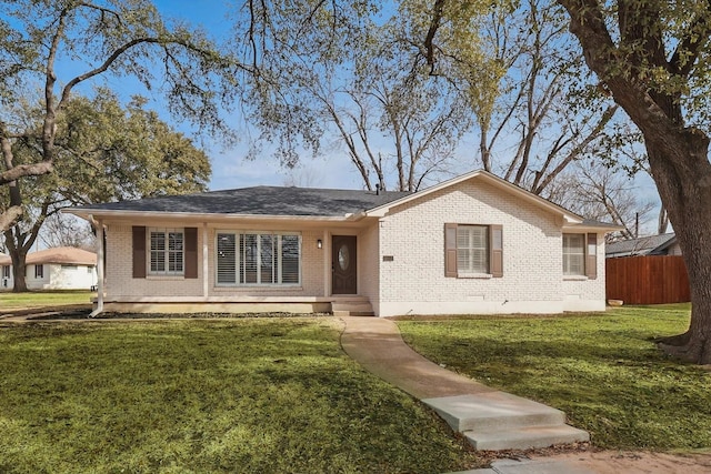 single story home featuring a front yard, fence, and brick siding