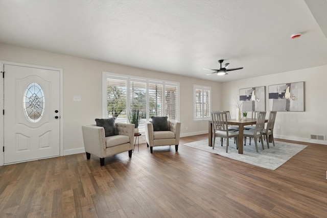 dining room with a ceiling fan, wood finished floors, visible vents, and baseboards