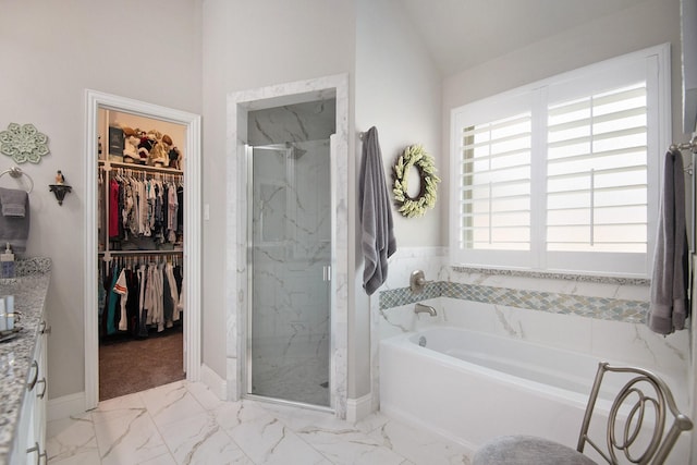 full bathroom featuring a bath, marble finish floor, a walk in closet, and a marble finish shower