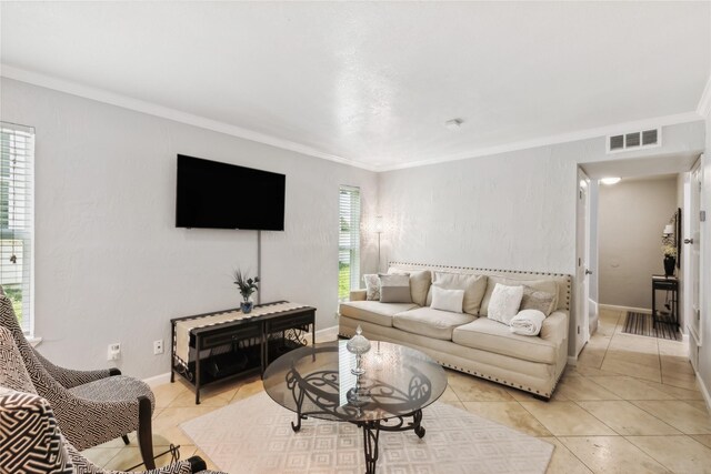 living area with light tile patterned floors, crown molding, baseboards, and visible vents