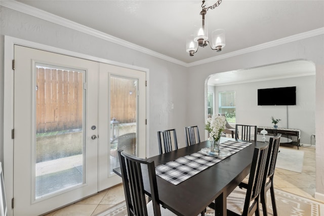 dining space with crown molding, arched walkways, light tile patterned floors, and an inviting chandelier