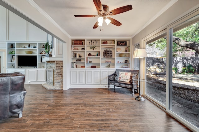 sitting room with dark wood-style floors, crown molding, and ceiling fan