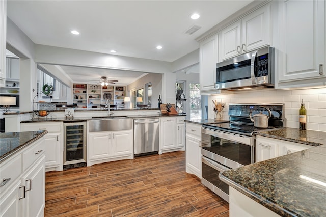 kitchen featuring wine cooler, visible vents, appliances with stainless steel finishes, a sink, and wood finished floors