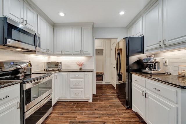 kitchen featuring wood tiled floor, appliances with stainless steel finishes, and white cabinets