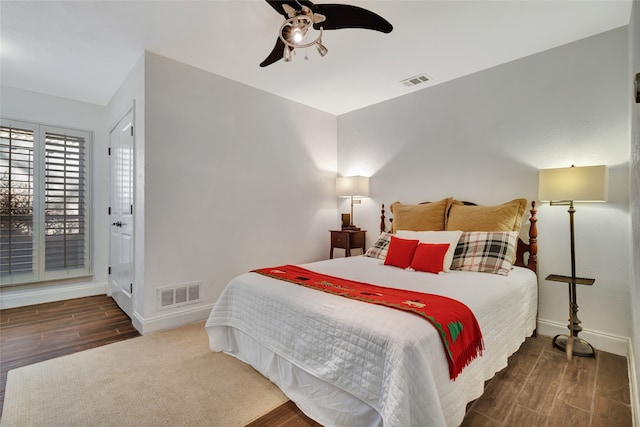 bedroom with visible vents, baseboards, and wood finished floors