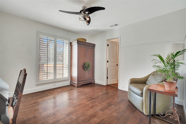 sitting room with baseboards, dark wood finished floors, visible vents, and a ceiling fan