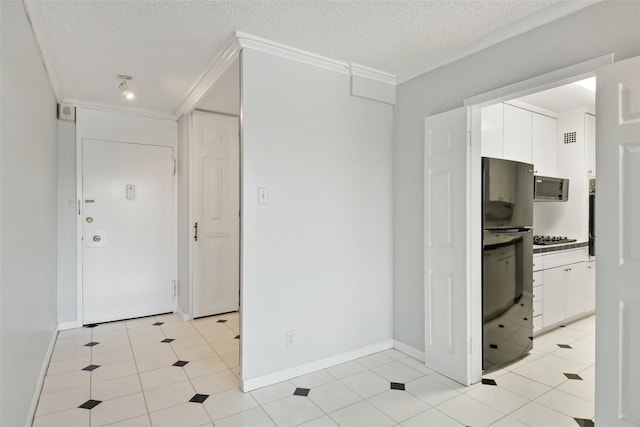 kitchen with stainless steel microwave, ornamental molding, white cabinets, and freestanding refrigerator