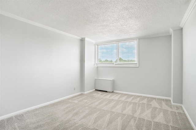 carpeted spare room with a textured ceiling, crown molding, and baseboards